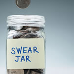 glass jar filled with coins labeled swear jar