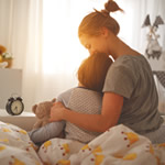 mother with child sitting on bed